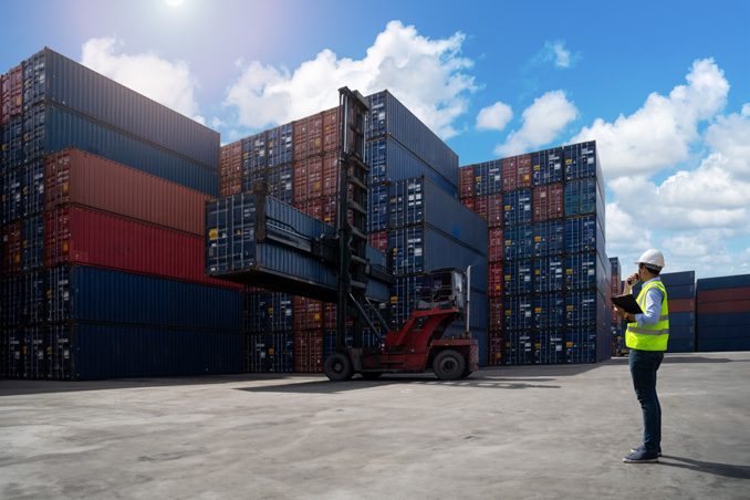 Worker coordinating customs clearance at container yard